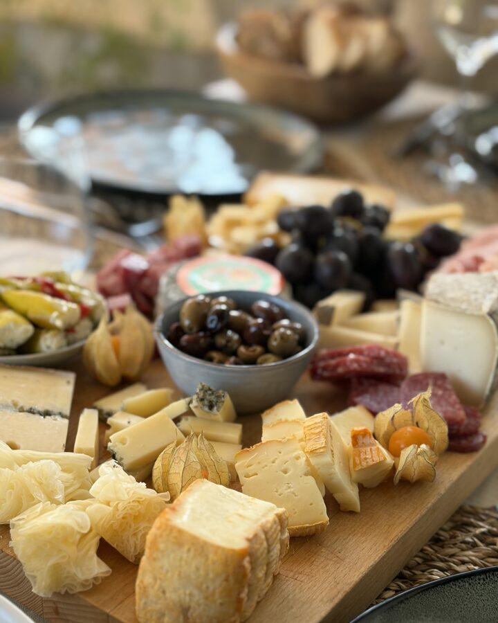 Käsebrett mit Tête-de-Moine-Rosetten, Morbier, Selles-sur-Cher, Trauben, Salami und Oliven