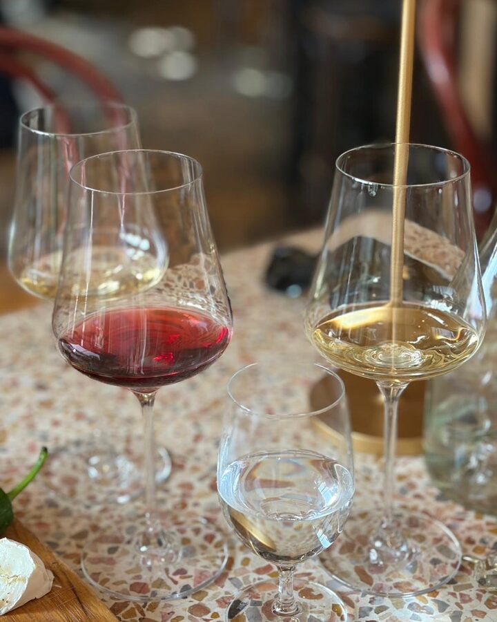 Mehrere Weingläser auf einem Tisch in der Bredouille Weinbar