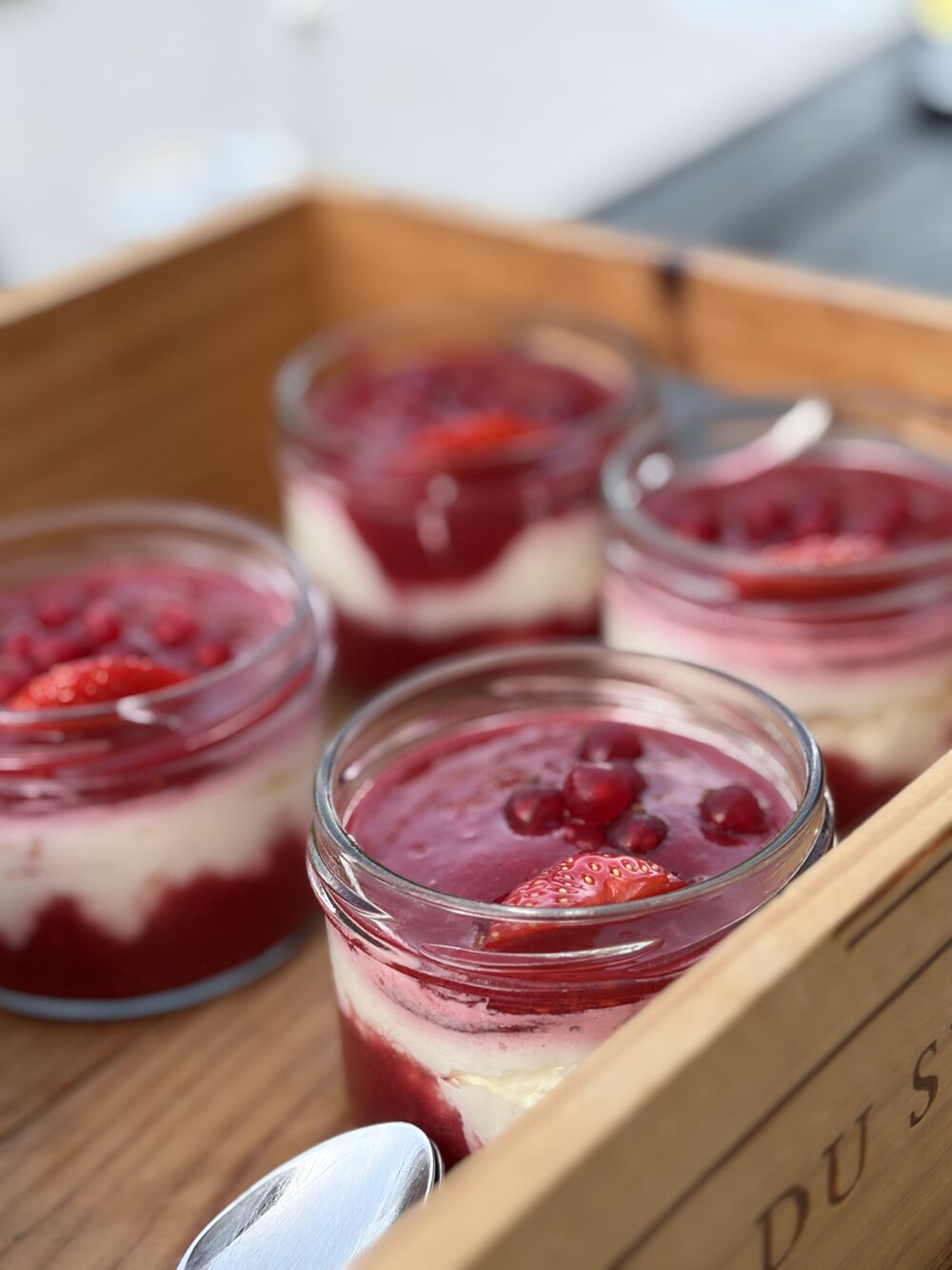 Sahnequark mit roten Beeren in kleinen Gläsern als Dessert
