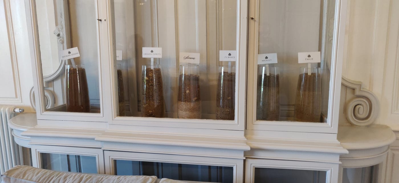 Glaszylinder mit Bodenproben einzelner Weinbergsparzellen in einer Vitrine bei Château de Pommard